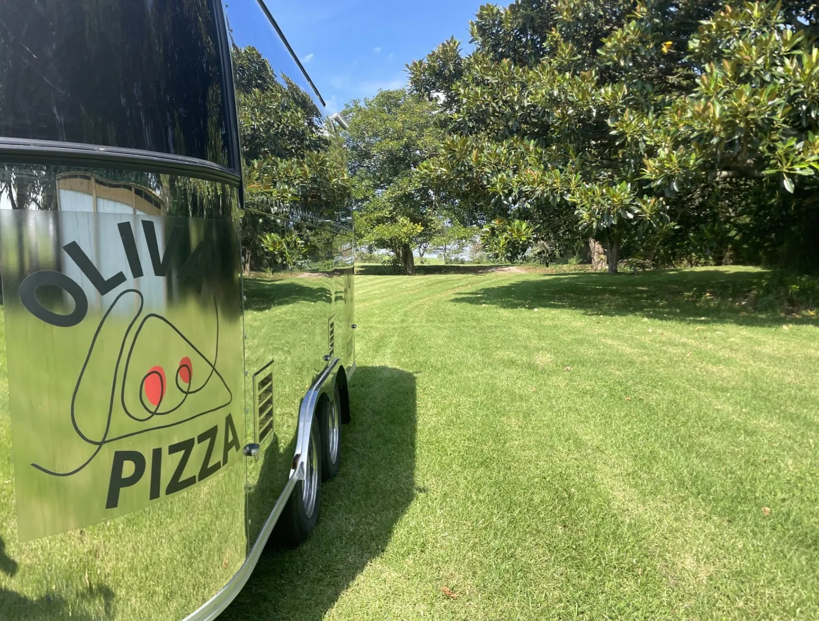 The Oliva Pizza logo on the mirror-chrome side of the trailer